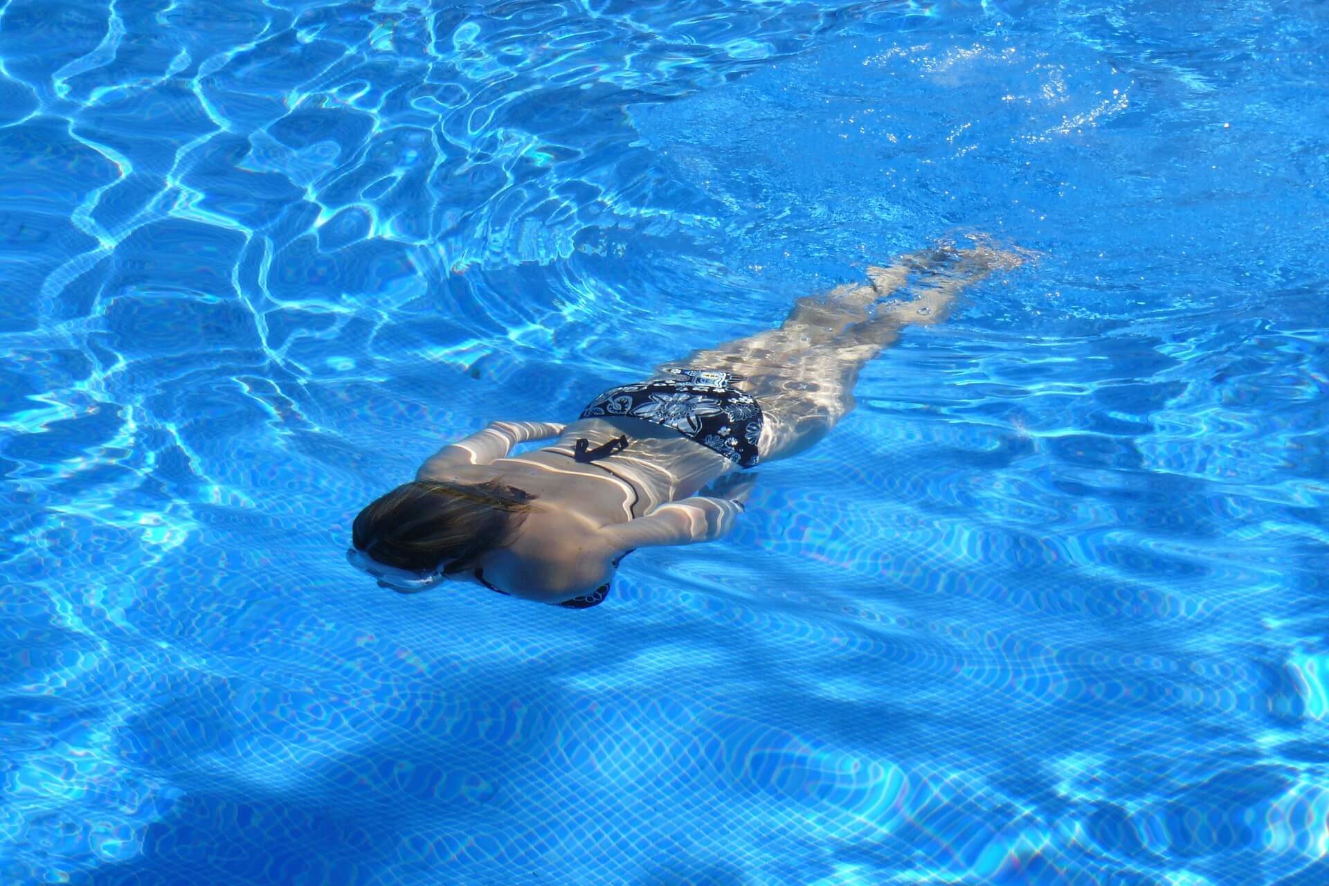 Femme nageant dans une piscine